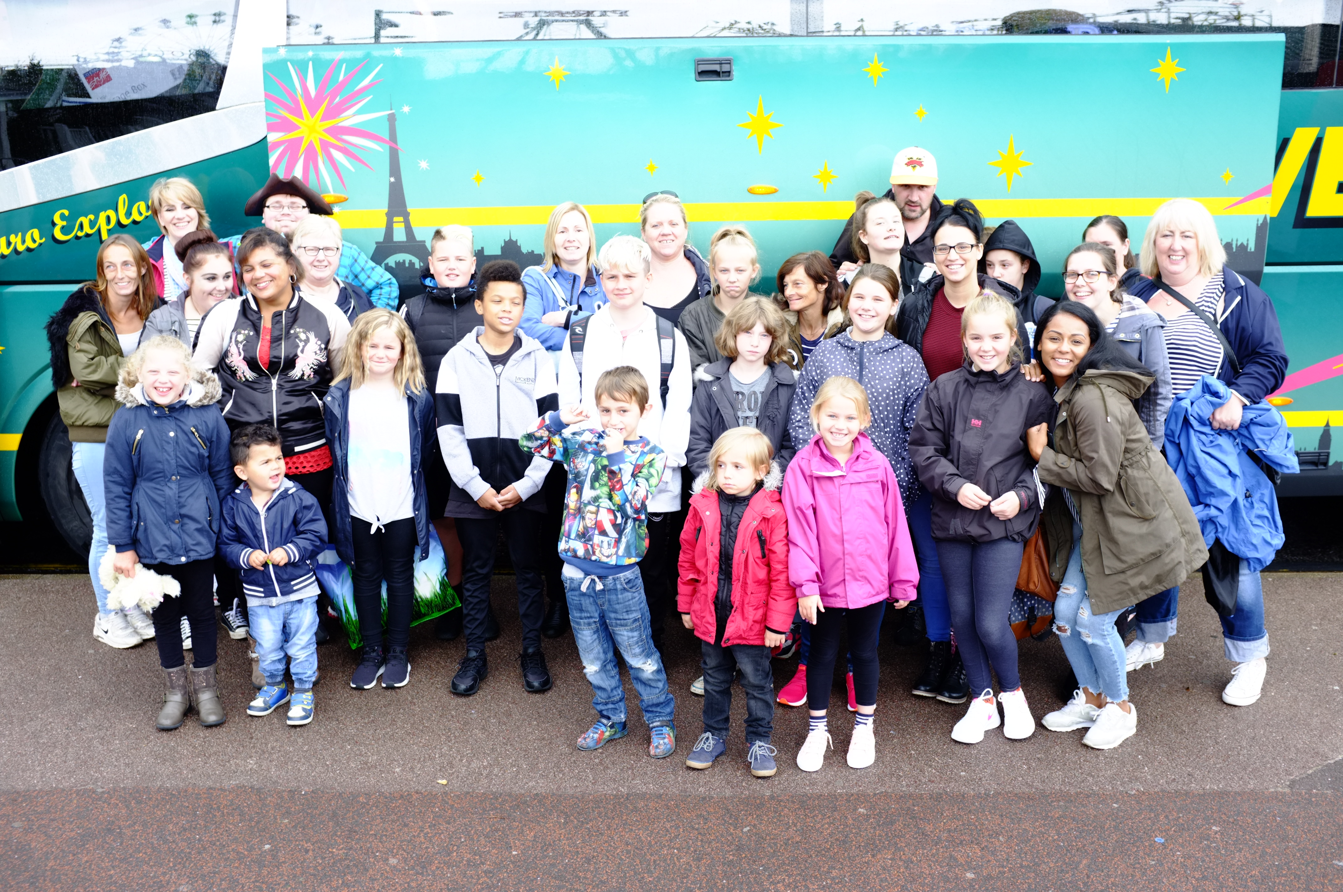 A group of people standing in front of a coach