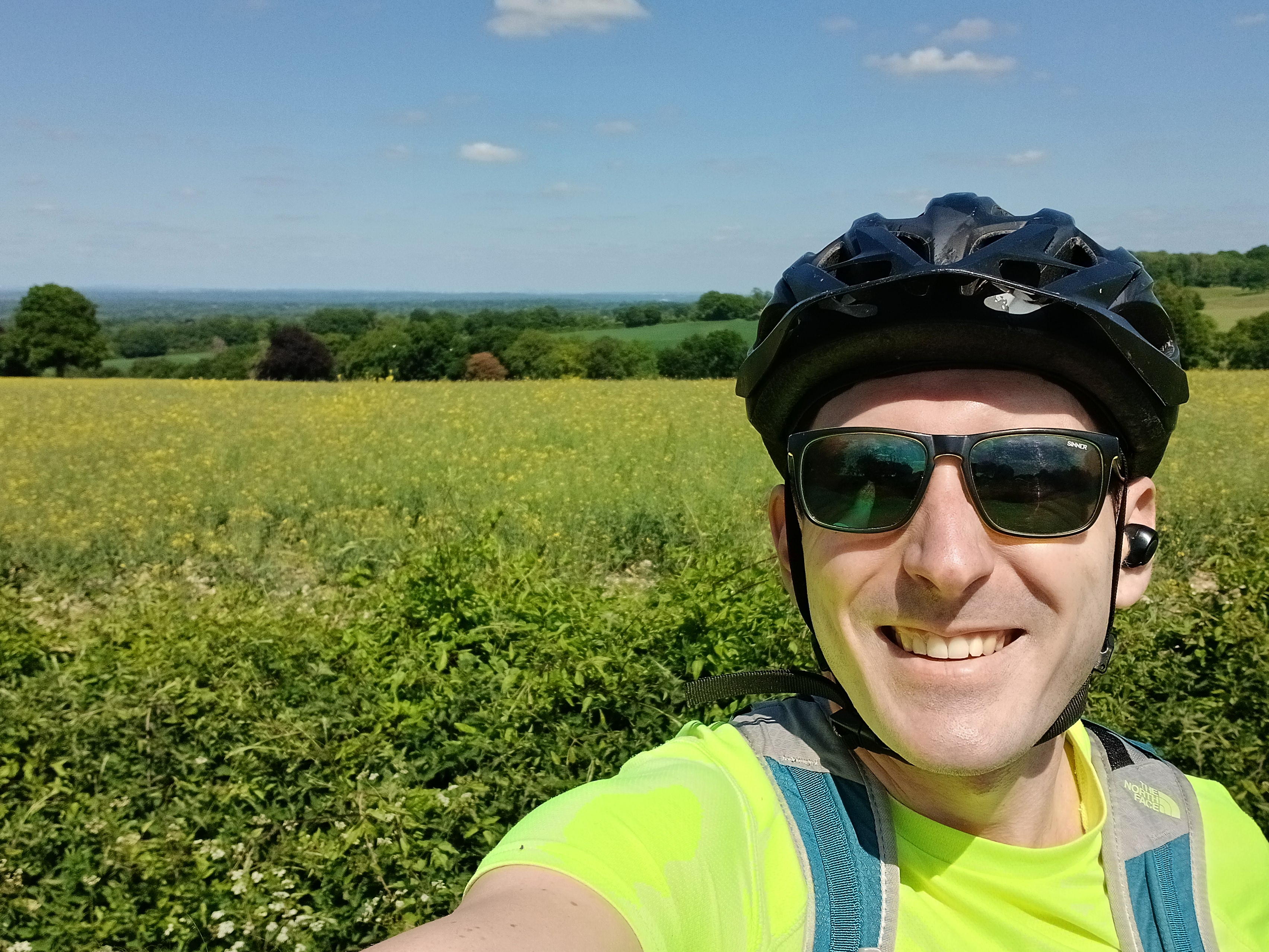 Cyclist taking a selfie with open fields behind