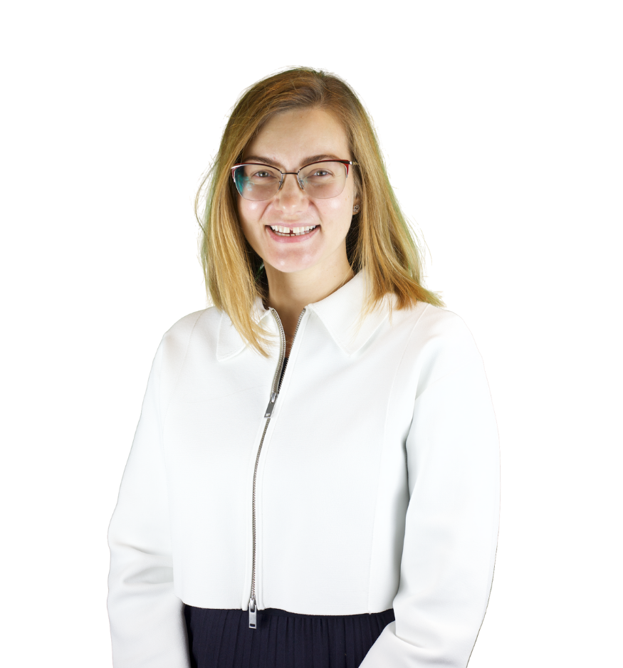 Trustee Iana wears a white zip up jacket and smiles at the camera.