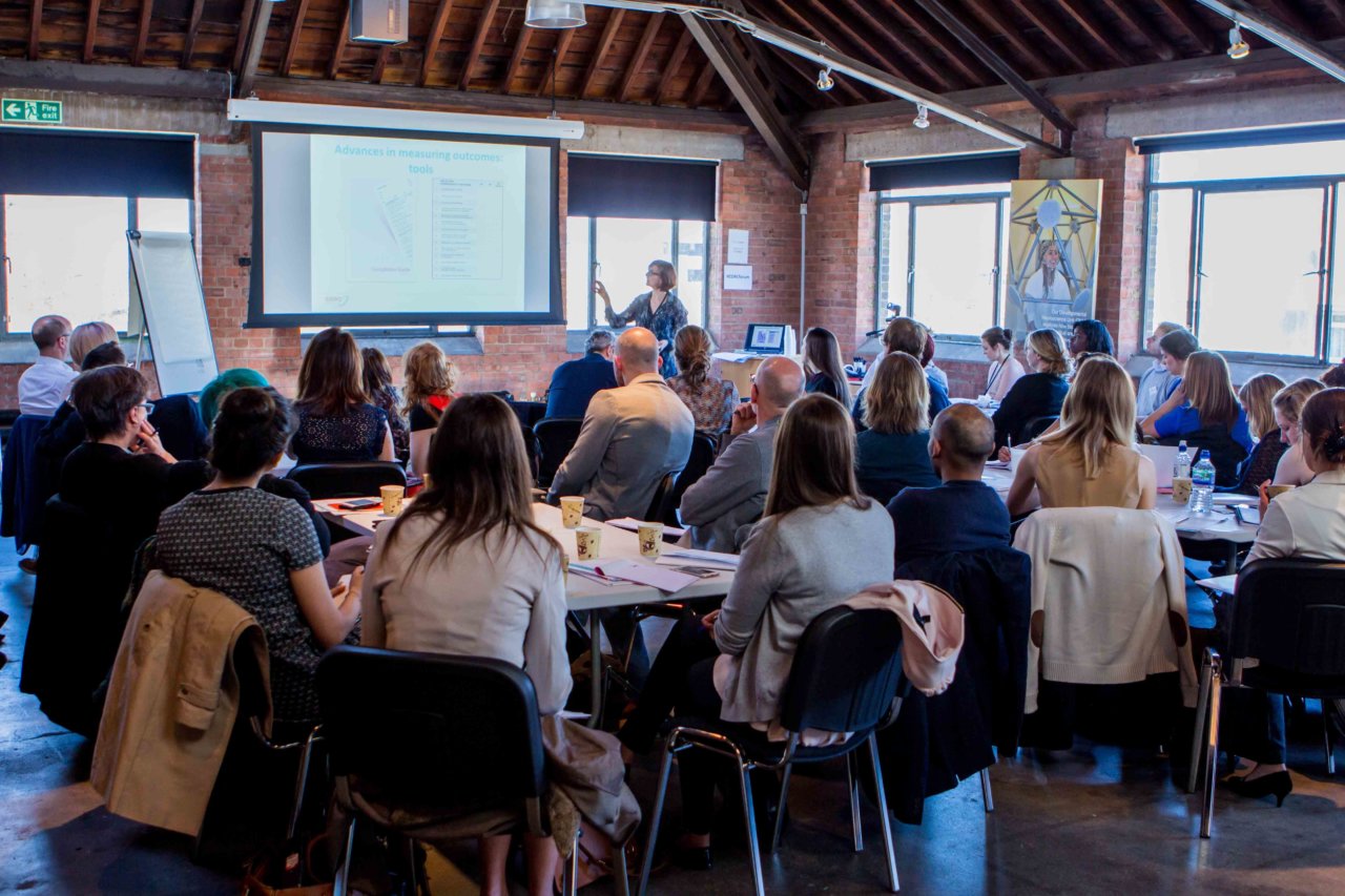 A woman giving a presentation to a room full of people