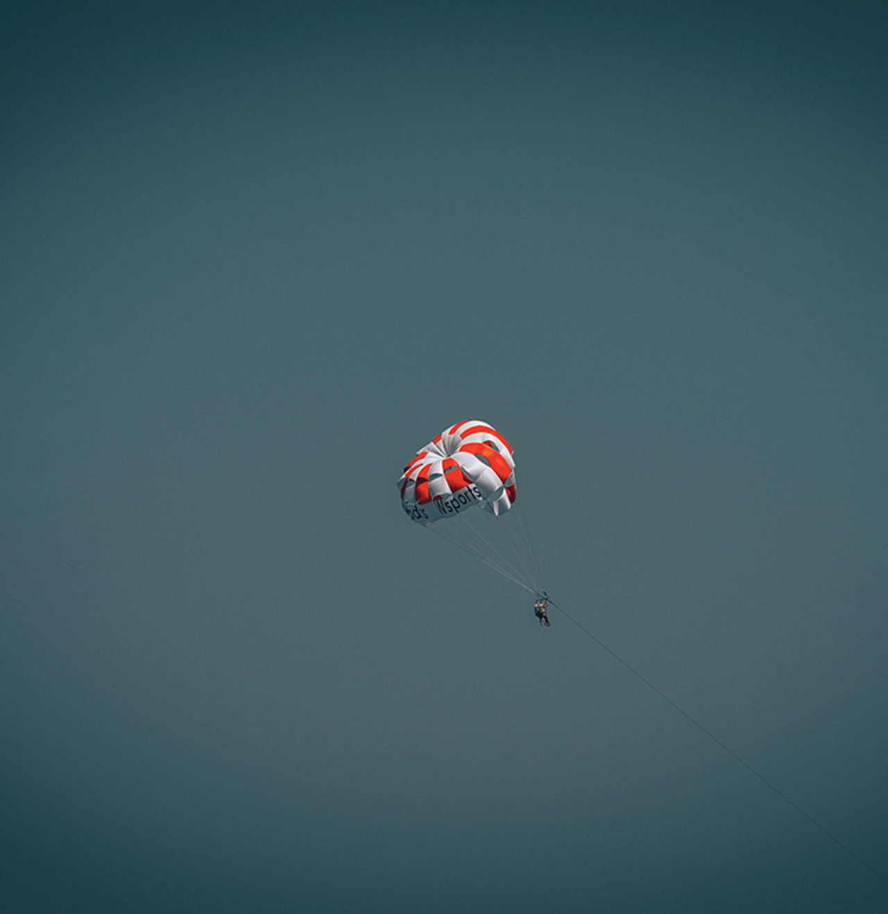 A person dangling from a balloon