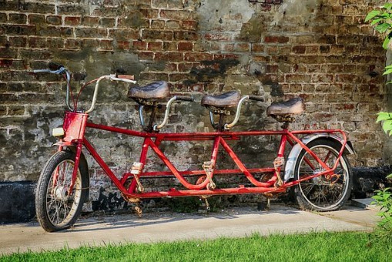 A bicycle with three saddles