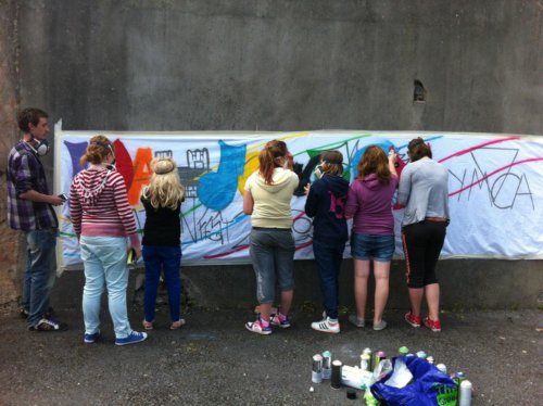 Young people painting a banner