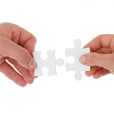 Two hands with two jigsaw pieces