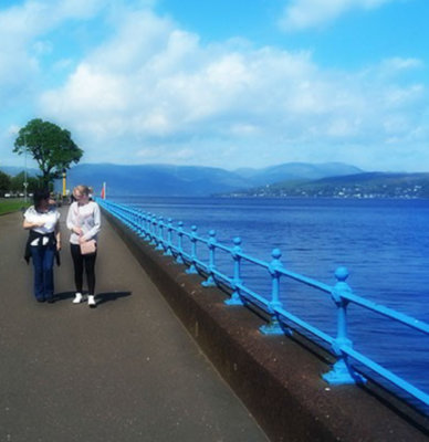 Two people walking by a loch