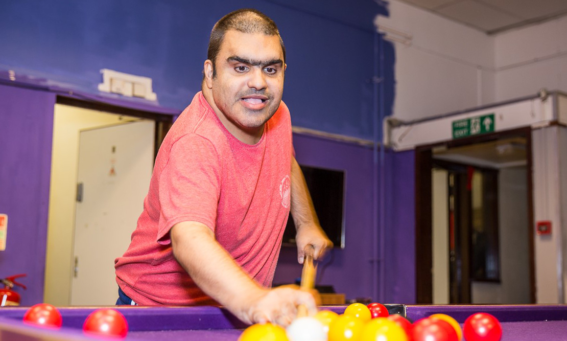 Disabled Asian man playing pool